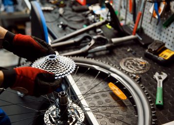 Bicycle repair in workshop, man installs cassette Bicycle repair in workshop, man installs cassette