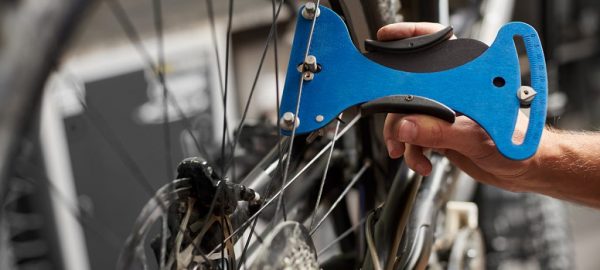 Male mechanic working in bicycle repair shop using tools