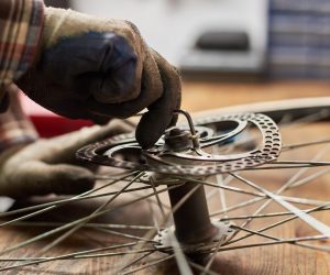 Male mechanic working in bicycle repair shop using tools